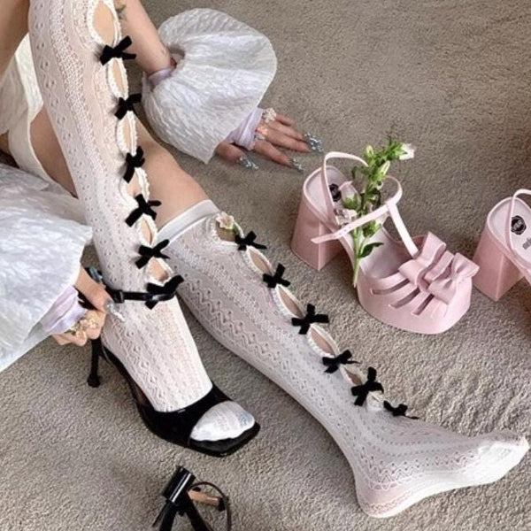 Vintage-style, slimming, over-the-knee socks featuring a flocked bow, cut-out details, and lace accents.