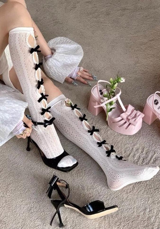 Vintage-style, slimming, over-the-knee socks featuring a flocked bow, cut-out details, and lace accents.