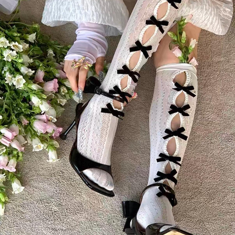 Vintage-style, slimming, over-the-knee socks featuring a flocked bow, cut-out details, and lace accents.