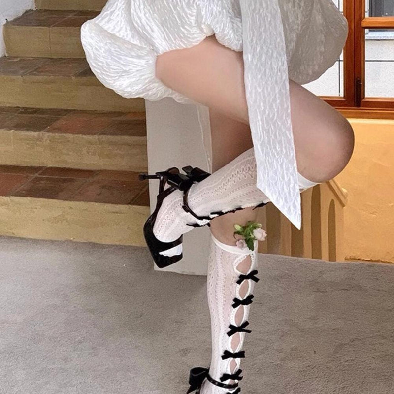 Vintage-style, slimming, over-the-knee socks featuring a flocked bow, cut-out details, and lace accents.