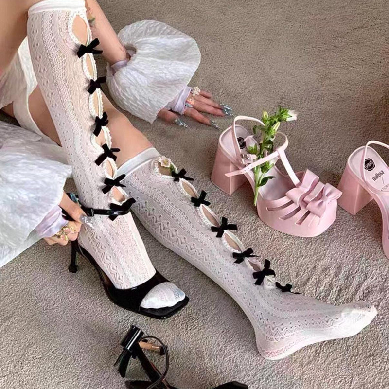 Vintage-style, slimming, over-the-knee socks featuring a flocked bow, cut-out details, and lace accents.